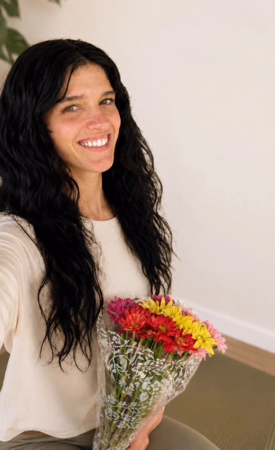 Flor Dragonetti sonriendo con un ramo de flores